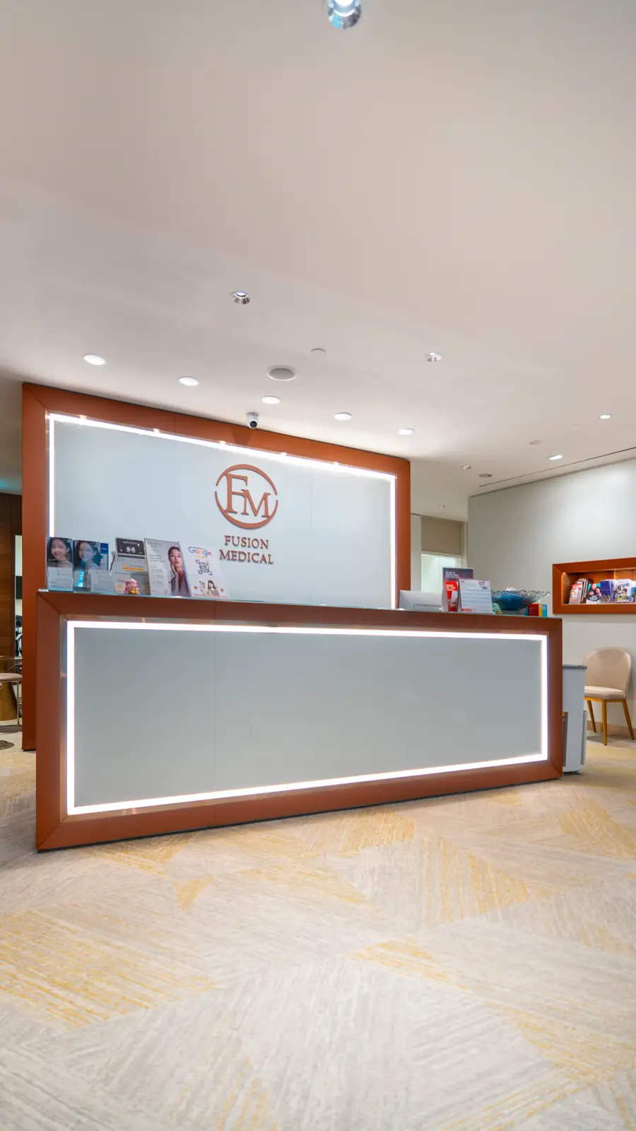 Fusion Medical reception desk with the clinic's FM logo at Wheelock Place