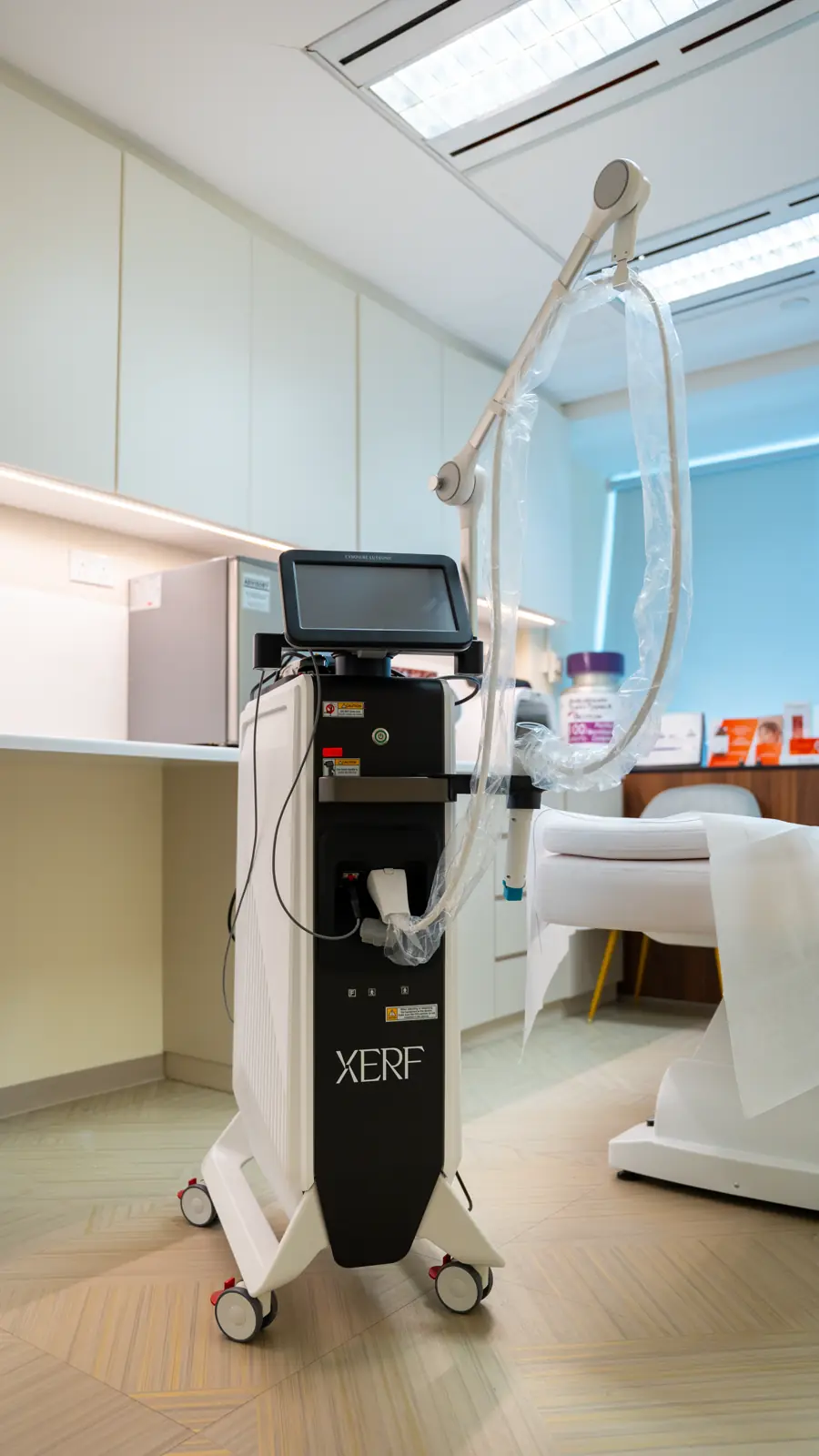 XERF™ system with its handpiece beside a treatment bed at Fusion Medical
