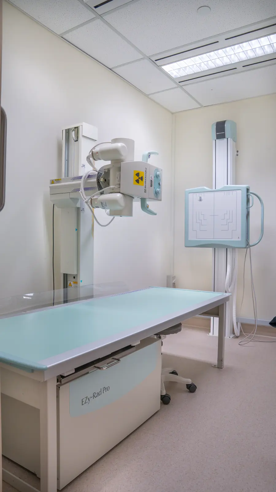 X-ray table and upright chest stand in the X-ray room at Fusion Medical