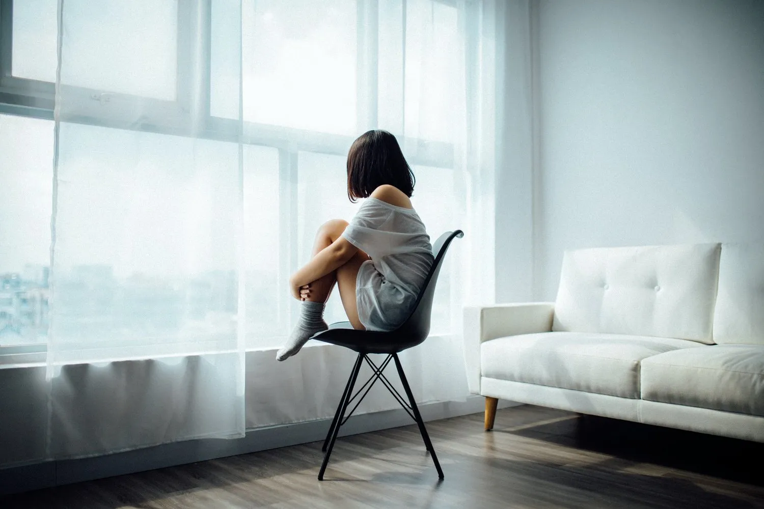 Woman sitting alone beside a window