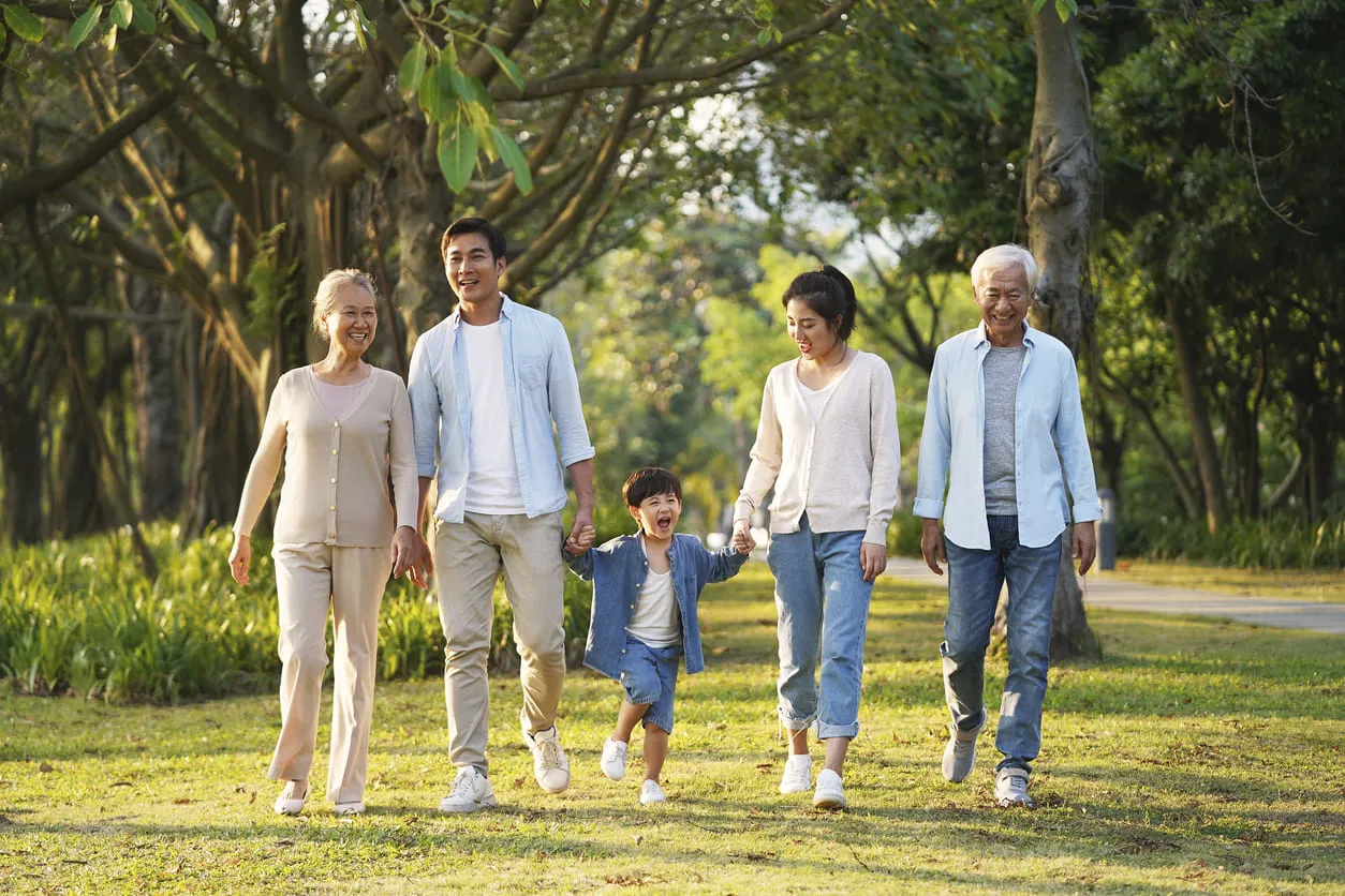 Three generations of a family walking through a park