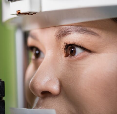 close up view of asian woman checking eyesight on blurred vision screener