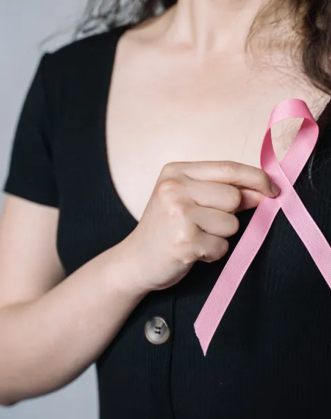 Woman holding a pink breast cancer awareness ribbon