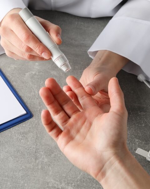 Clinician preparing a finger-prick blood glucose test